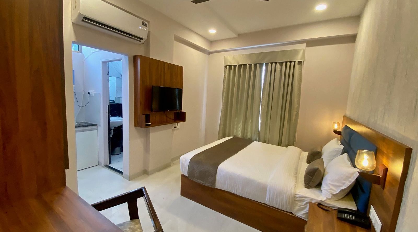 Wide angle view of room with TV and modern amenities  at Hotel Mumbai House, Indore