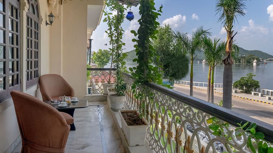 A balcony with two cushioned seats offering a view of the lake| Panna Vilas Udaipur