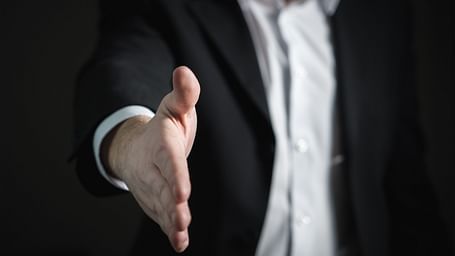 image of a man dressed in business formals extending his hand for a handshake