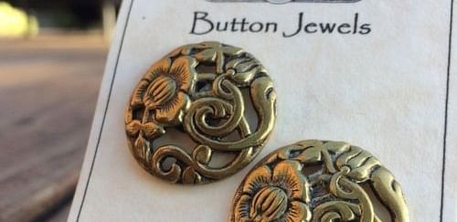 A pair of intricately designed earrings displayed on a branded jewelry card.