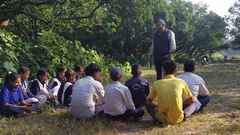 A person teaching the importance of recycling to a group of students at Golden Tusk
