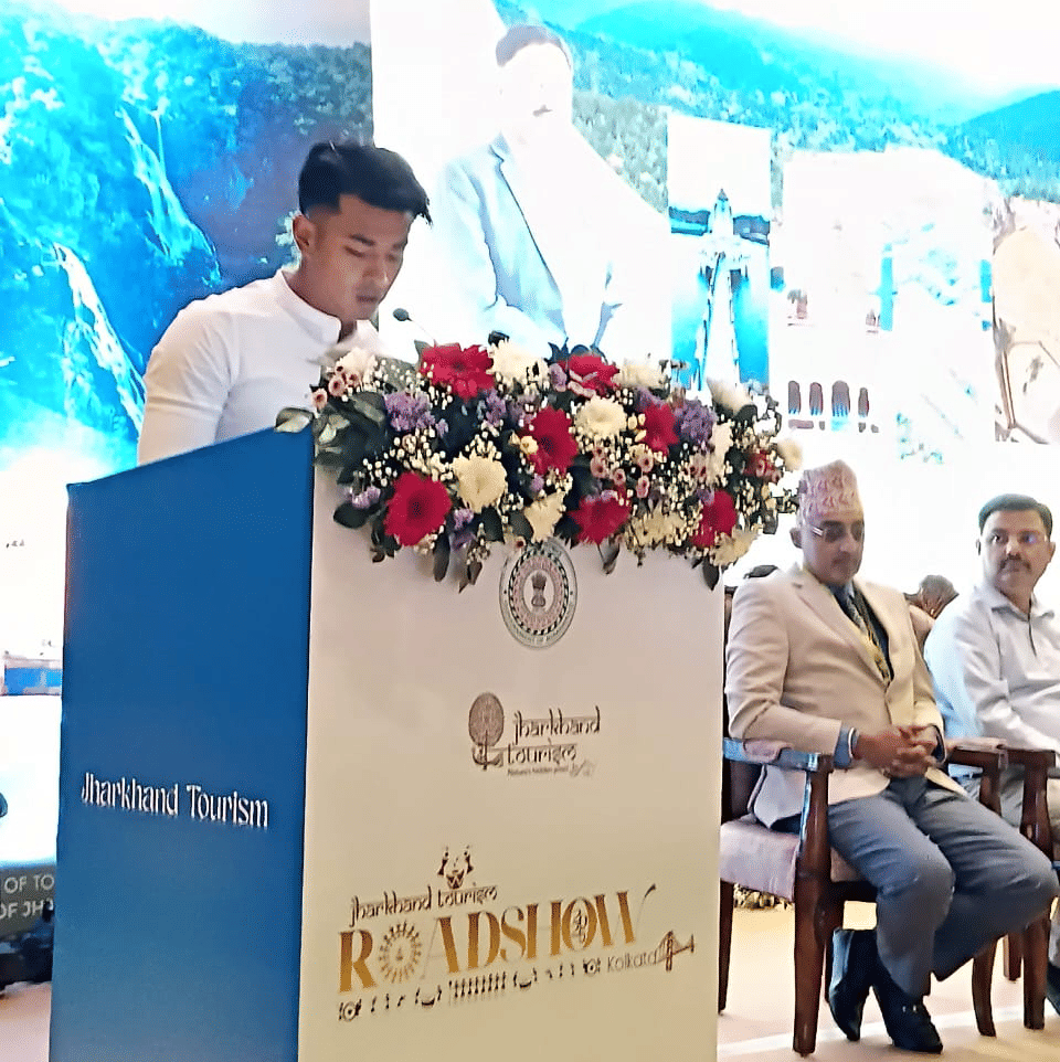 A person standing on stage, addressing the audience and delivering a speech at an event