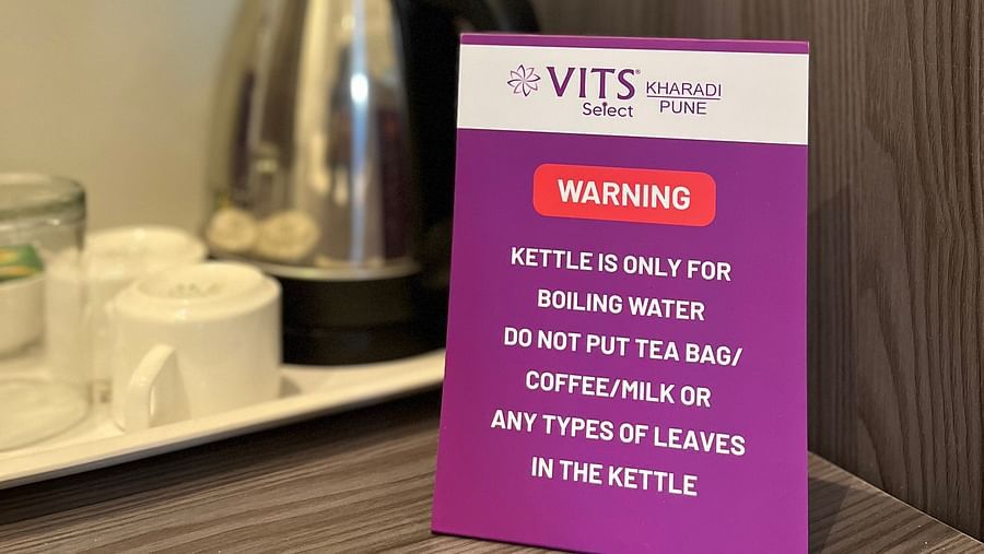 A close up shot of a kettle and tea cups placed on a wooden table at VITS Select Kharadi, Pune.