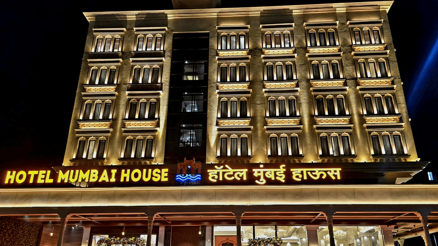 Illuminated hotel exterior at night showcasing grand façade at Hotel Mumbai House, Digha, Airoli.