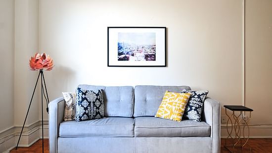 a blue couch will asian artwork on the backgroud wall
