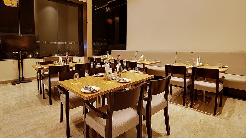 Interior of a restaurant with wooden tables and chairs for a family each, in a clean environment