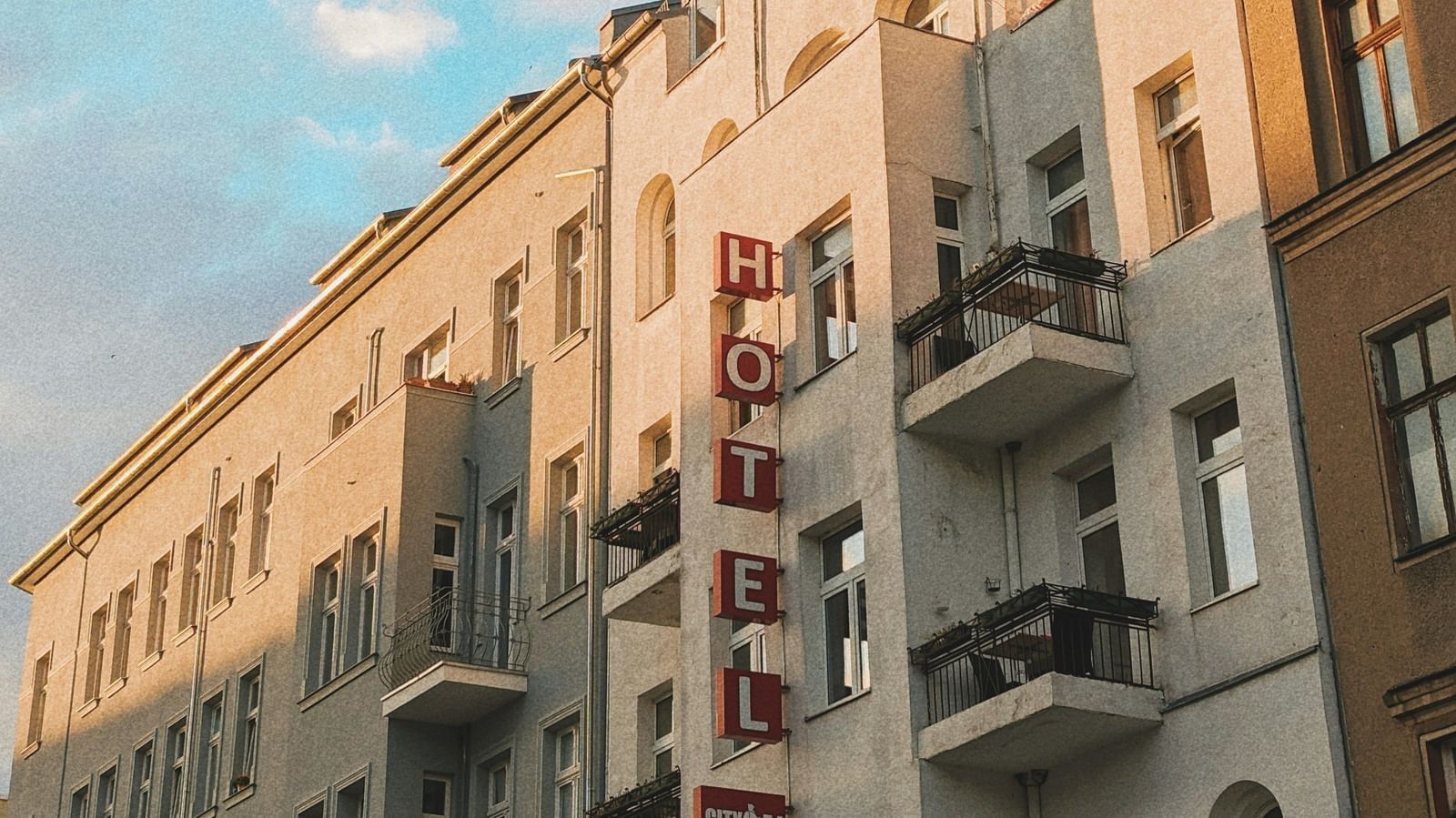  A low-angle view of a row of European-style buildings with balconies under a blue sky