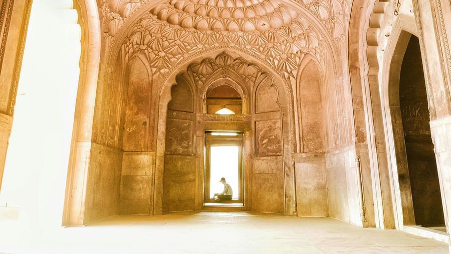 An interior shot of an ancient domed structure with intricate patterns on the ceiling, leading to a bright opening.