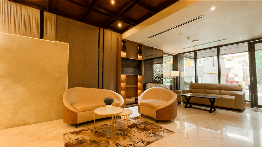 The common seating area featuring a comfortable couch set placed in the middle of the lobby of F Hotels, Bengaluru.