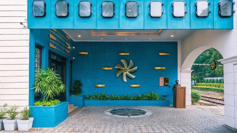Another angle of the hotel's entrance during the day with a focus on the blue facade and the nautical-themed propeller decoration. - Polo Floatel