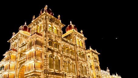 Illuminated palace glowing against the night sky with intricate architecture.