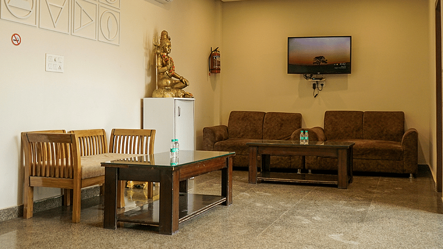 Reception area at Five Elements Hotels, Haridwar, featuring a welcoming setup with two chairs and a table in the corner