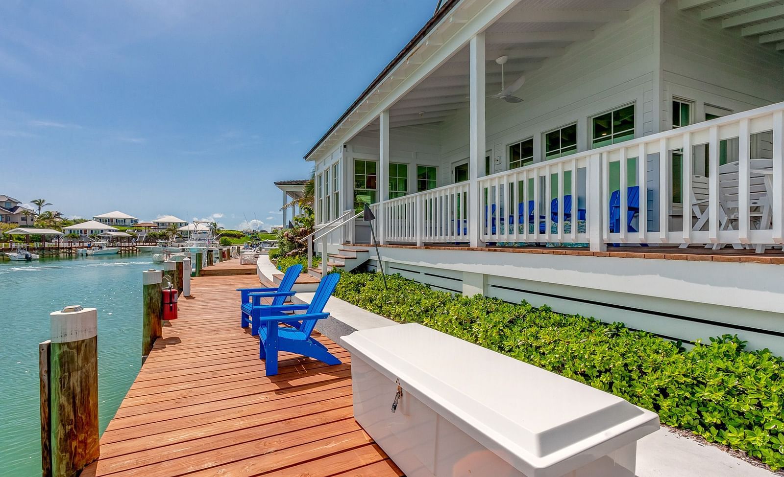 Blue chairs on the dock facing the ocean | Abaco Inn