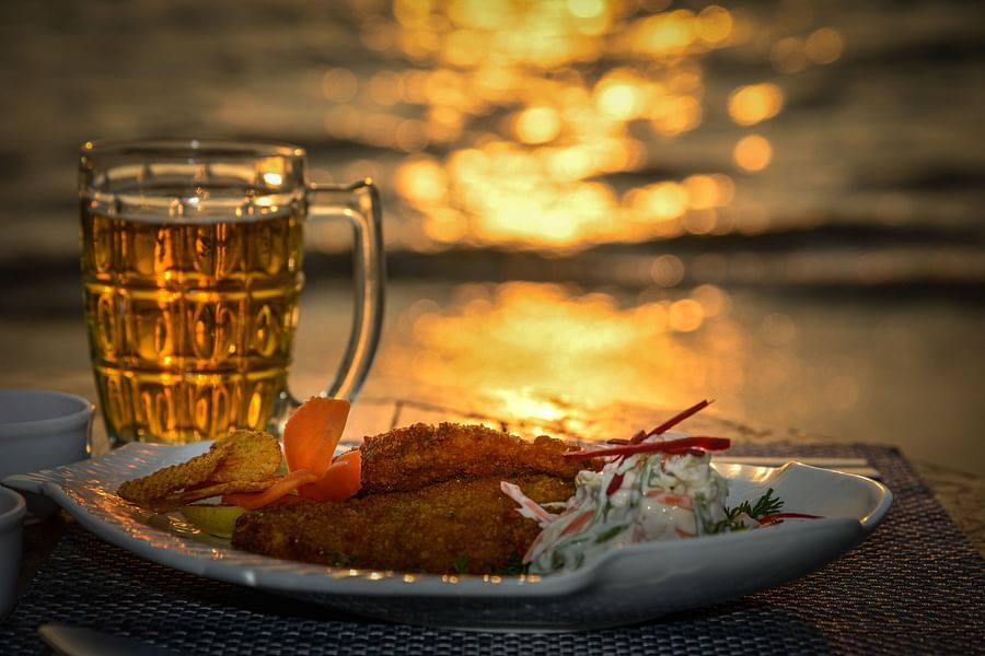 a glass of beer and plate of sea food
