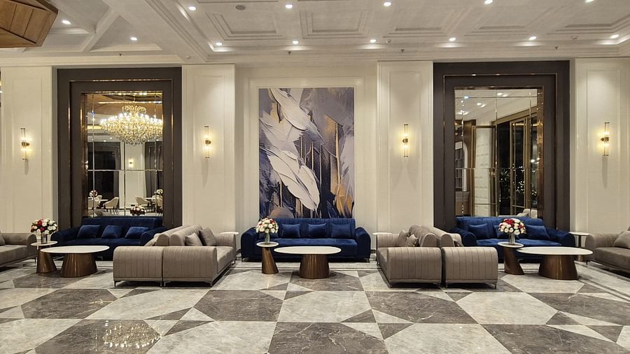 Luxurious event space with blue velvet sofas, marble flooring, and warm lighting at Ramada by Wyndham Sonipat Murthal