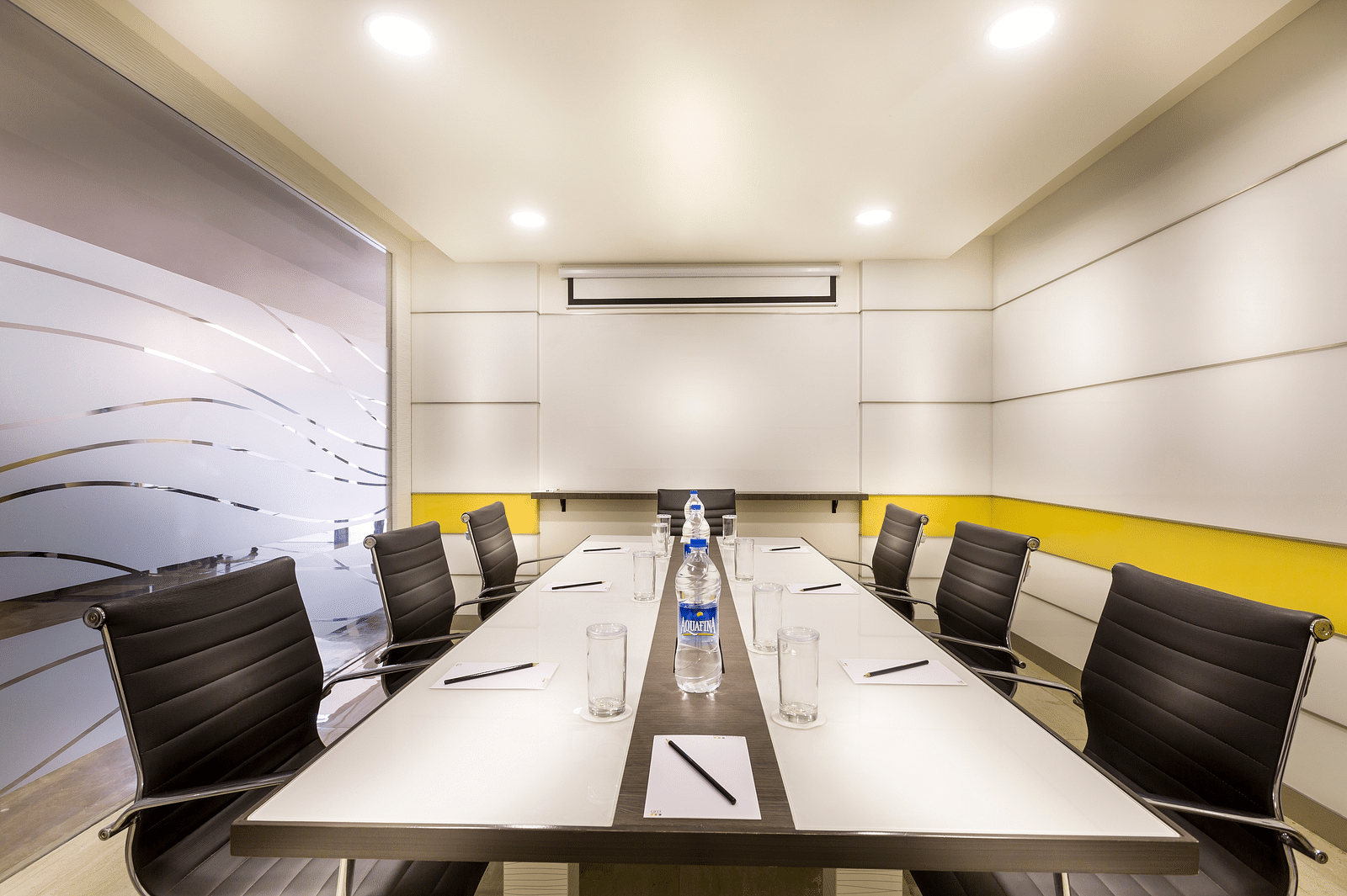 An image of the Board Room with black chairs placed next to each other in front of a white table at Regency Tiruttani by GRT Hotels.