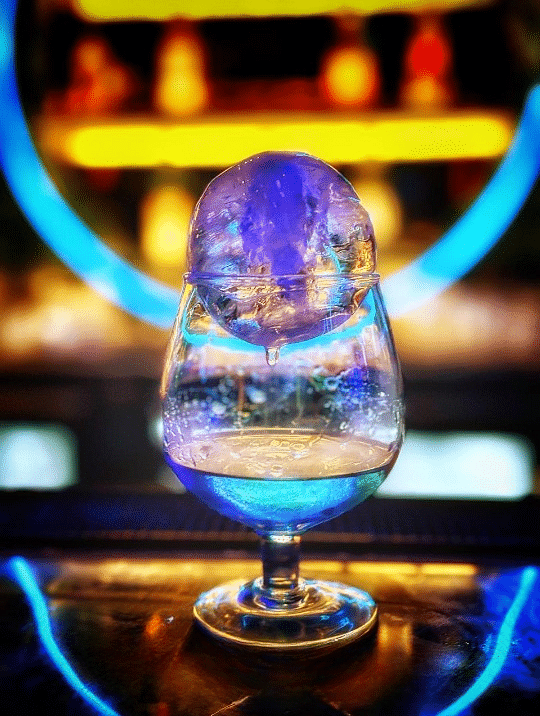 An elegant drink with a bright light displayed in the background at Cenneys Gateway.