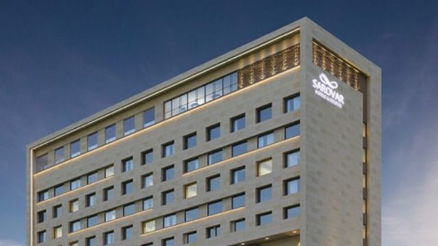 An exterior view of the Sarovar Premiere Alwar hotel building from a street perspective.