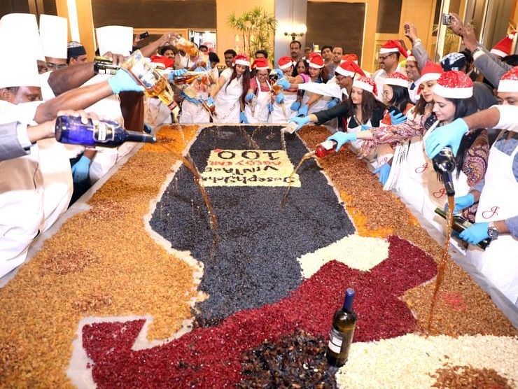 Group of people mixing ingredients for a cake together.