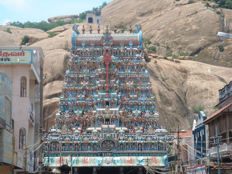 Facade shot of Tirupparamkunram Murugan Temple with rock mountain in the background.