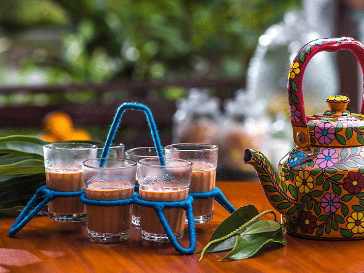 Decorative tea set with a colourful kettle and glasses on a tray