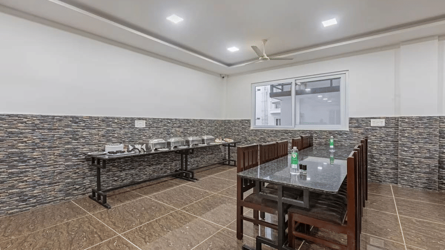 Simple indoor dining setup with tiled flooring and buffet corner, offering a clean and casual dining experience at Siri Ambari Resorts and Spa.