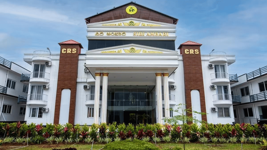 Grand exterior view of Siri Ambari Resorts and Spa, featuring a majestic white building with landscaped gardens in front.