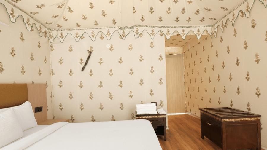 A room at Grassfield Riviera Resort, featuring a large bed, bedspreads, pillows, and tables.