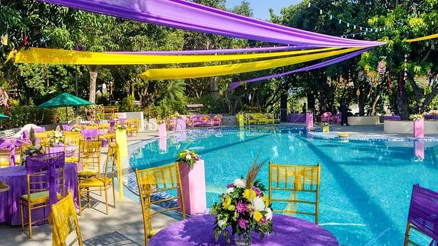 alt-text Festive poolside wedding venue with colorful decorations.