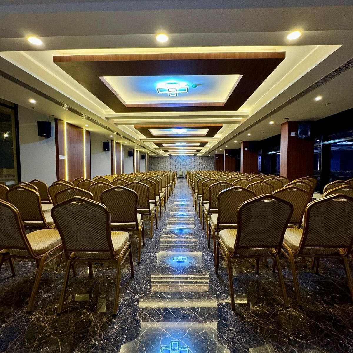 Image of a banquet hall with chairs and lights on the ceiling at Le Royale Palace.