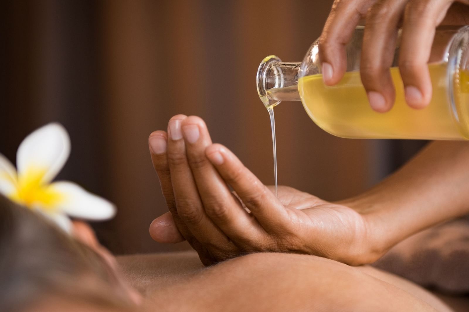 an image of a person pouring oil on their hands to massage their client - Rhythm Lonavala