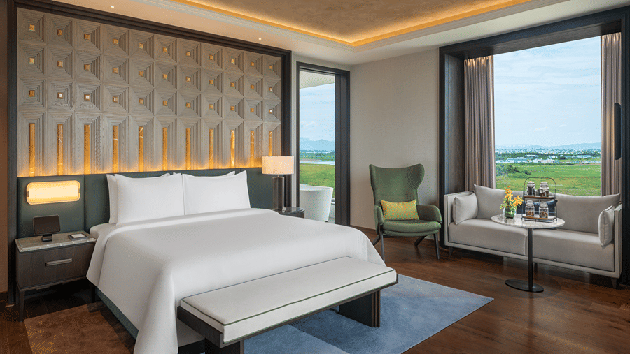 Executive Suite Room 8027 master bedroom with a bed and garden view seating at The Residency Signature Madurai.