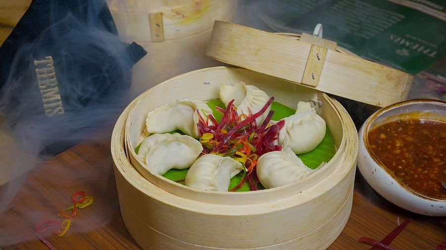 An image of dumplings in a basket placed on a table at Themis Barbecue House, NSP Pitampura