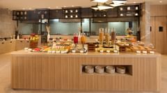 The breakfast buffet with fruit, juice, and cereal at Riviera Sarovar Portico, Pathankot.
