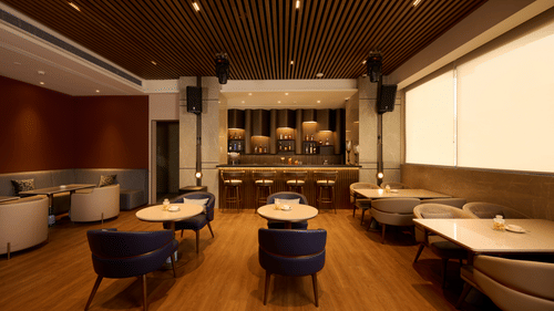 The hotel bar with a bar counter and various seating areas at Riviera Sarovar Portico, Pathankot.