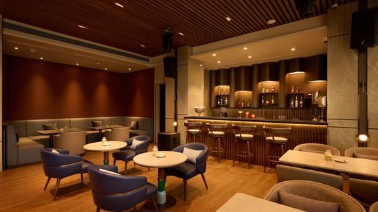The bar with a counter and multiple seating areas at Riviera Sarovar Portico, Pathankot.