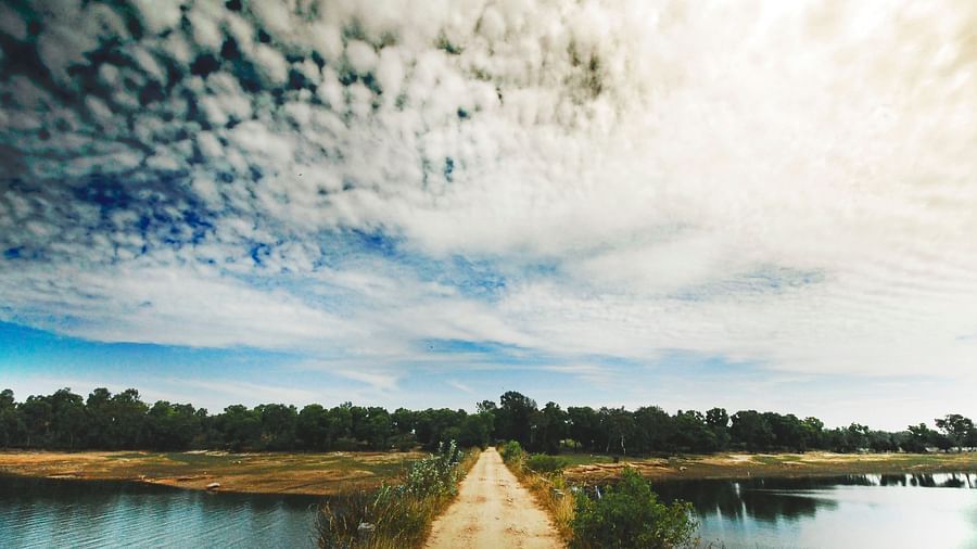 image of a kacha road in the middle with a bright backdrop with clouds