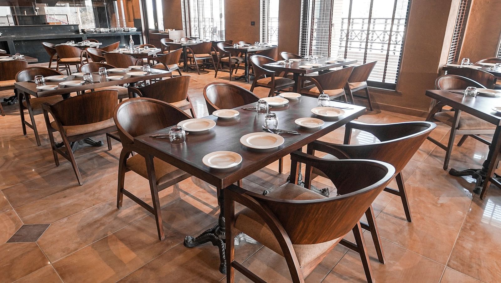  A spacious restaurant interior with many tables and chairs, ready for dining at Aamaghati Wildlife Resort.