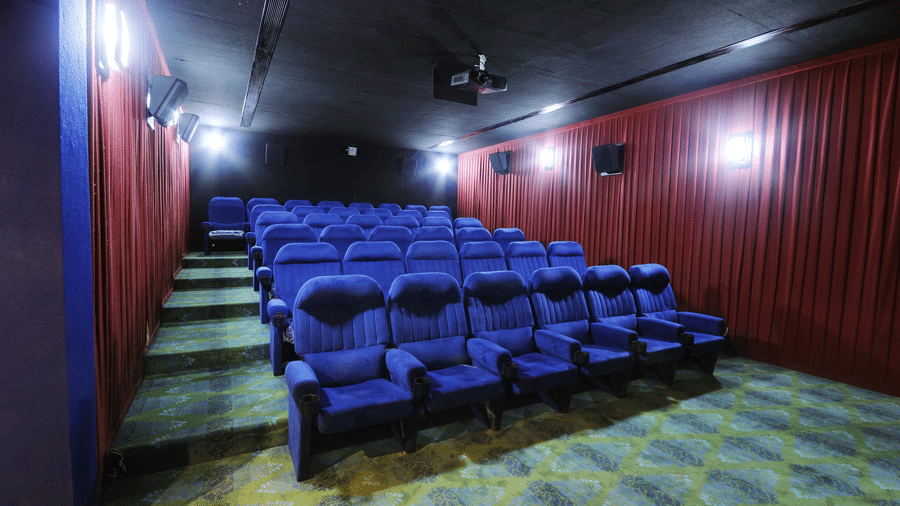 Private theatre with rows of blue seats and red wall panels – Narayani Heights Hotel & Resorts