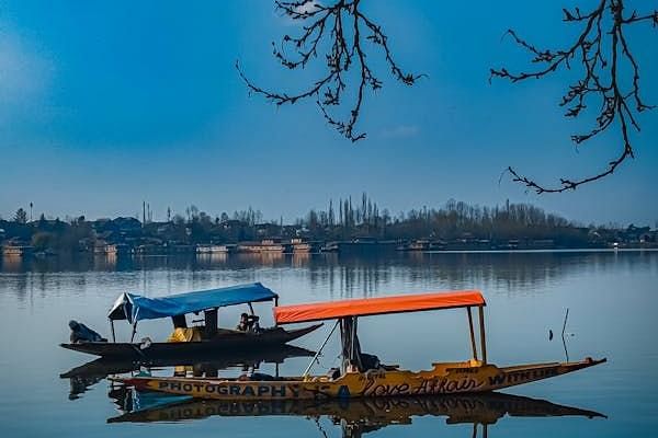Two boats on a lake with trees in the background.