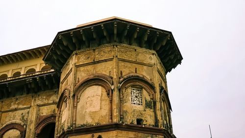 A view from below of an old building in Tijara with clear sky in the background.