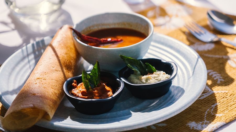  A close-up view of a plate with dosa and three bowls of side dishes on a well-set table at BluSalzz Villas - The Green Roof, Bhimtal.