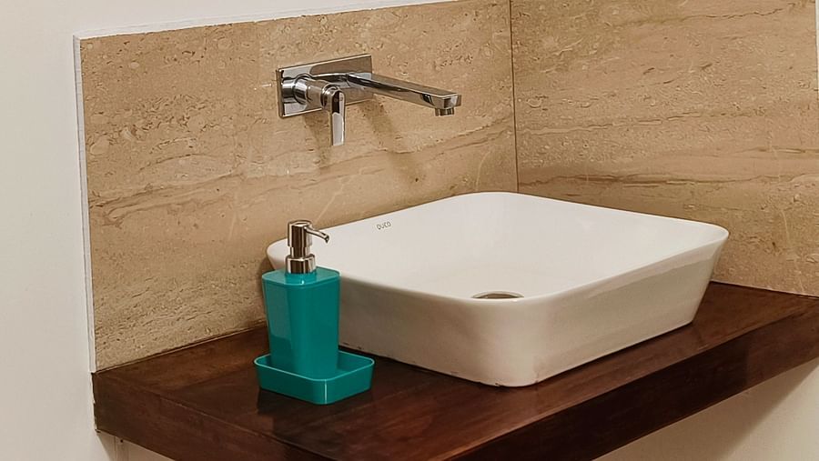 A sink and a mirror in the top of it in the washroom of 101 non-ac room at Ananda Holiday Home, Wayanad 3