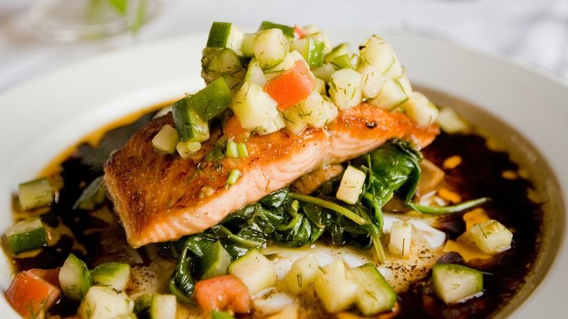 A fish fillet garnished with sauce and vegetables - Stone Wood Riverfront Resort, Siolim