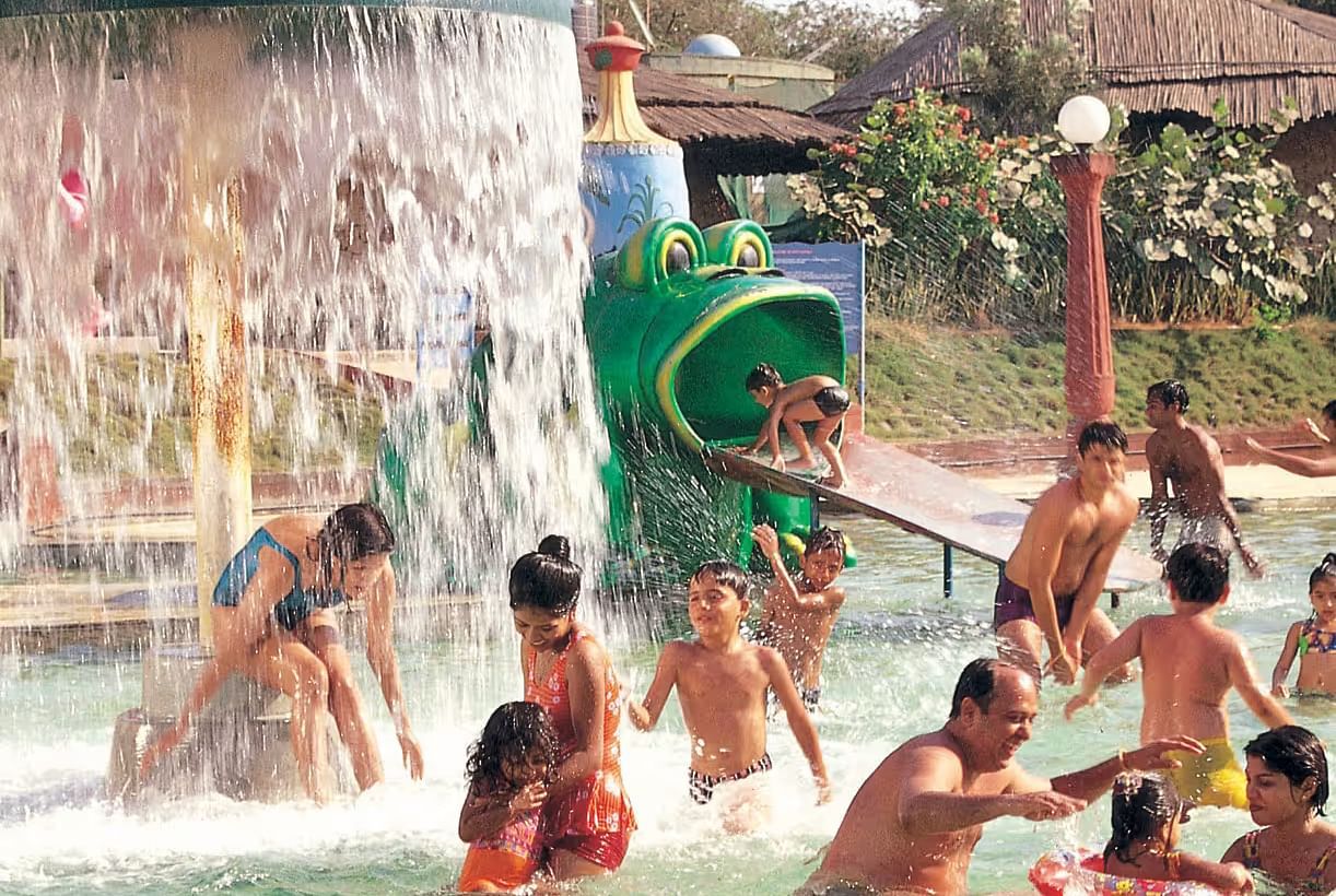Kids with adults enjoying Frog Slide at Water Kingdom in the water