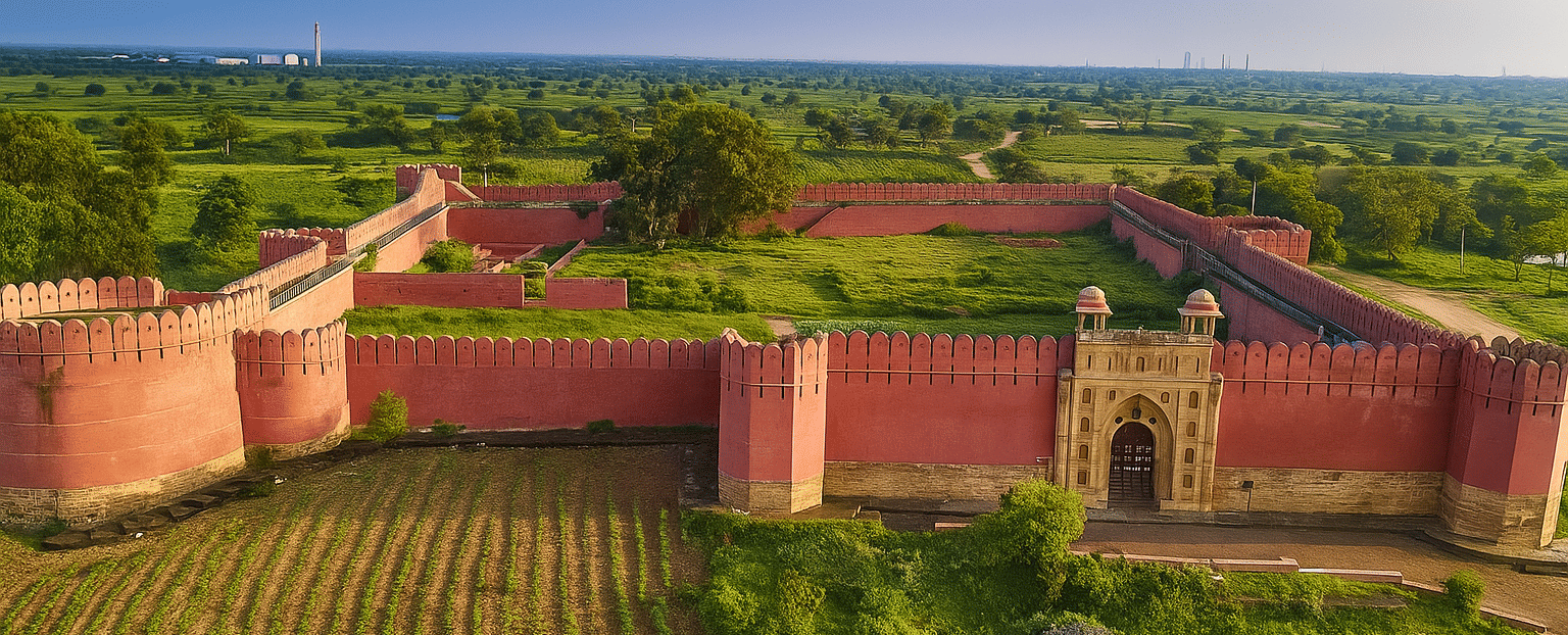 An aerial view of Bhadra Fort's sandstone walls and surrounding lush fields