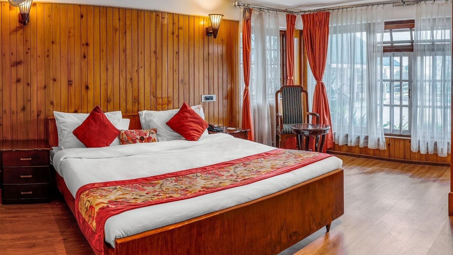 A room at Summit Barsana Resort & Spa, Kalimpong with a double bed and large windows