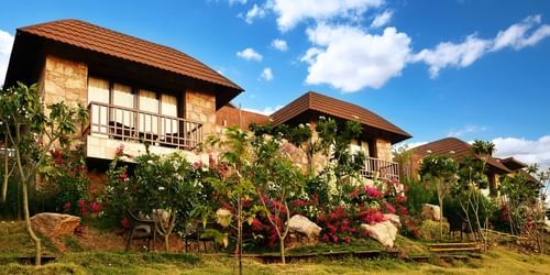 the facade of Ananta Udaipur with lush green lwans and trees 
