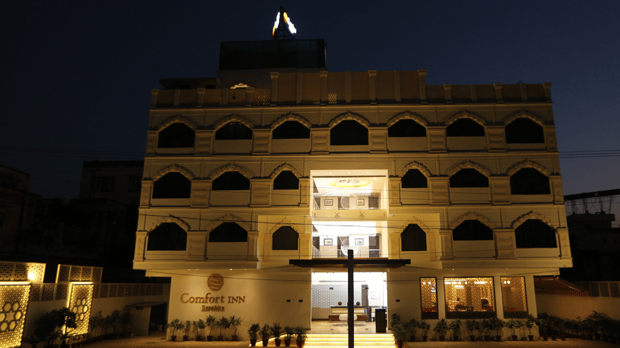 The facade of Comfort Inn Sapphire by Eastlynn Collections, Jaipur, illuminated at night.