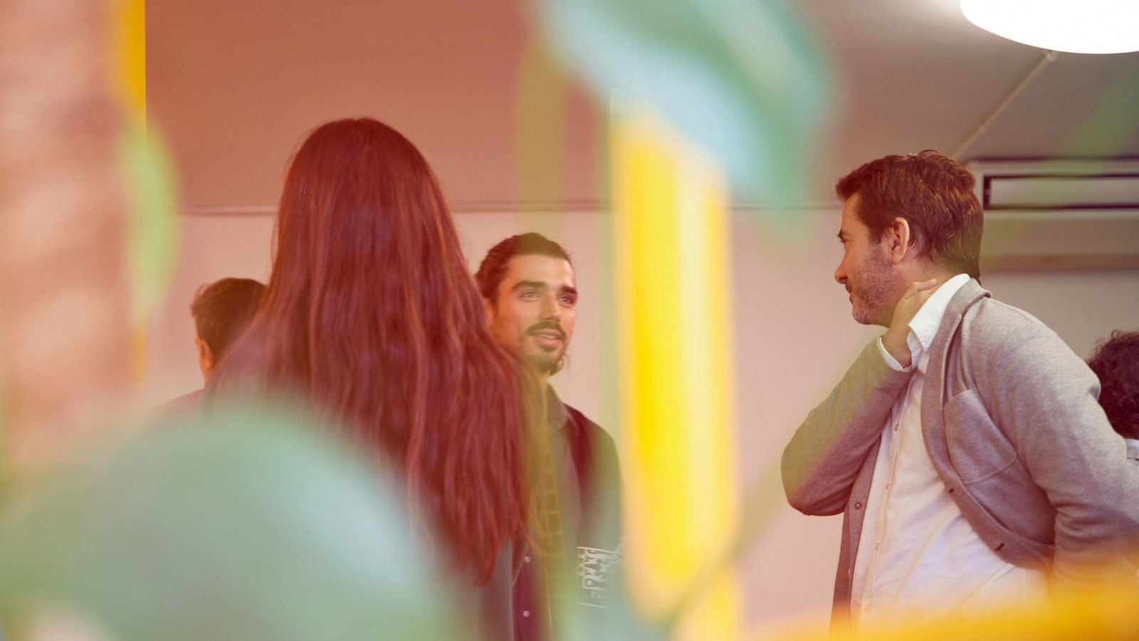 A group of people speaking to each other in an office environment